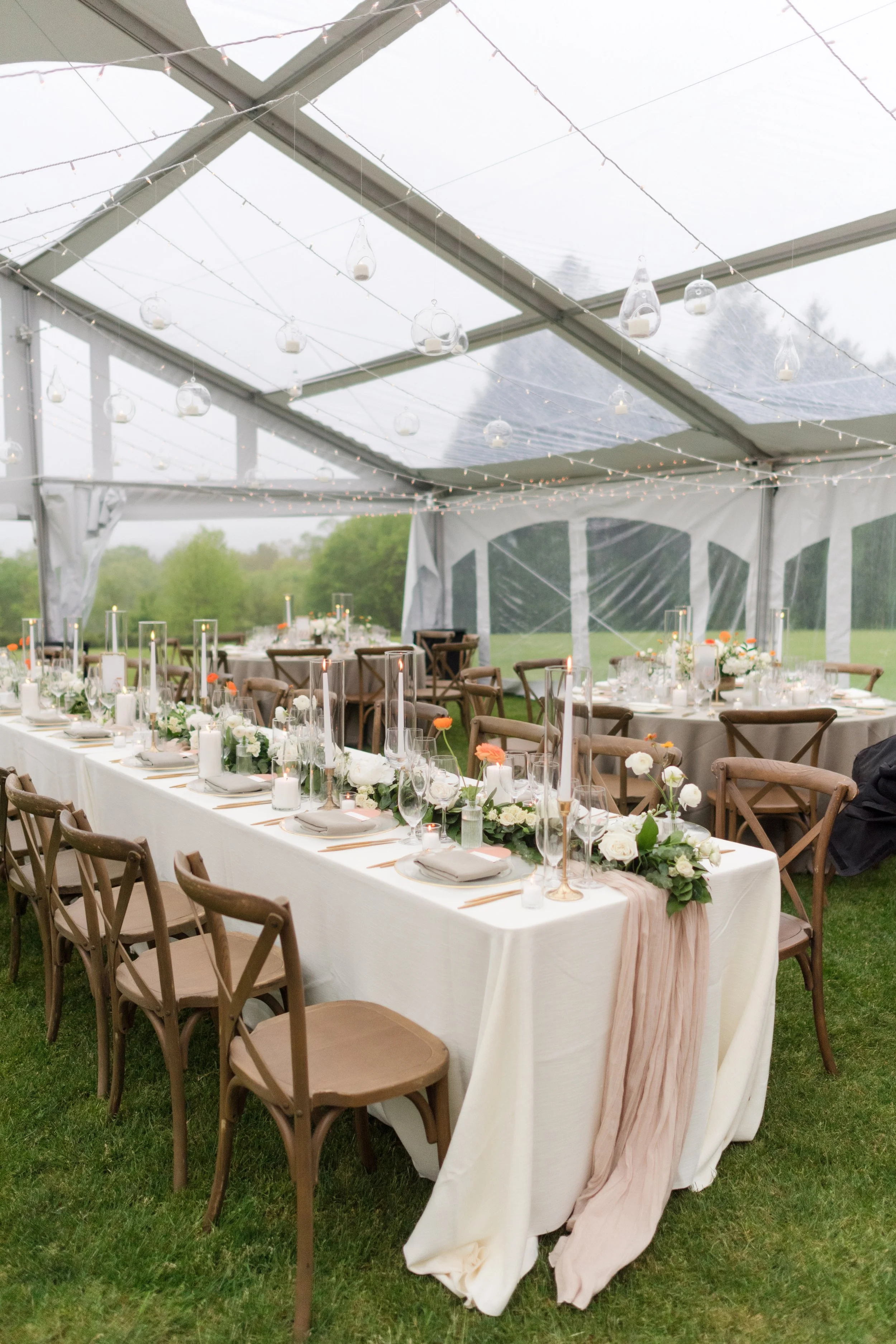 Elegant Berkshire wedding reception under a clear tent with candles and floral tablescape